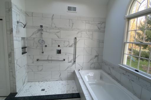 Modern open shower and tub in bright inviting space